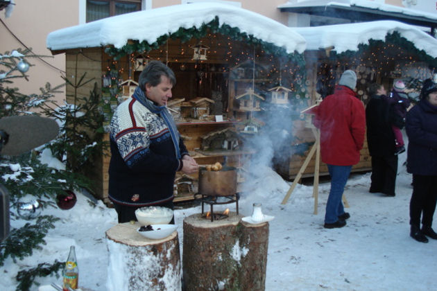 Günter Lüftenegger bereitet beim Christkindlmarkt in Anger auf einem Holzstock gebackene Schneebälle zu (wurde mehrmals bereits im Fernsehen gezeigt).
